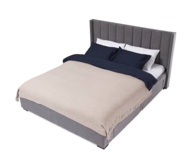 Beyaz arka planda çarşafları olan rahat gri yatak.