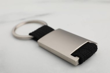 Beyaz mermer masada metal anahtarlık, yakın plan.