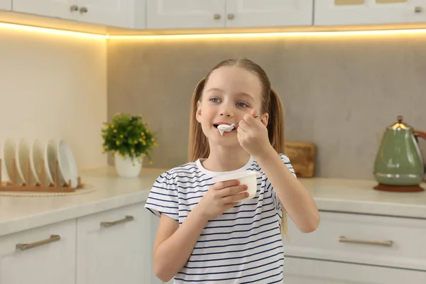 可愛いです女の子食べるおいしいヨーグルトでキッチン — ストック写真