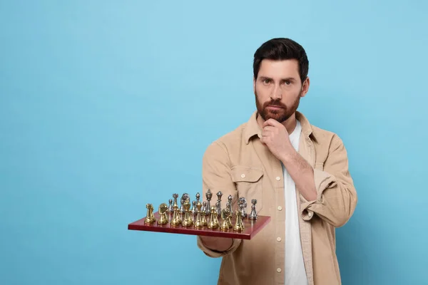 Προσεκτικός Άνθρωπος Κρατώντας Σκακιέρα Κομμάτια Του Παιχνιδιού Γαλάζιο Φόντο Χώρος — Φωτογραφία Αρχείου