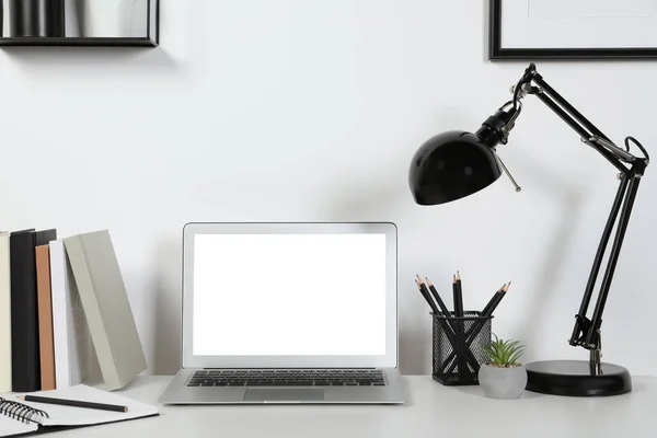 自宅で白い机の上にノートパソコン ランプや文房具と居心地の良いワークスペース — ストック写真