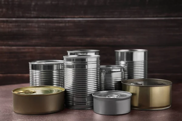 stock image Many closed tin cans on brown table