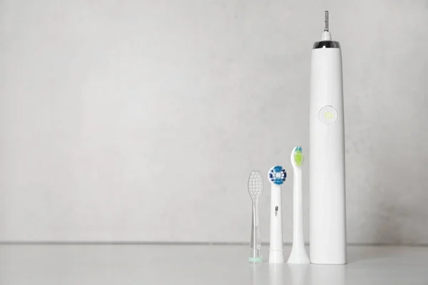 Elektrische Zahnbürste Und Ersatzbürstenköpfe Auf Hellem Hintergrund Platz Für Text — Stockfoto