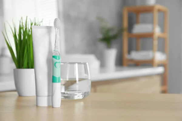 Electric Toothbrush Tube Paste Glass Water Wooden Table Bathroom Space — Stock Photo, Image
