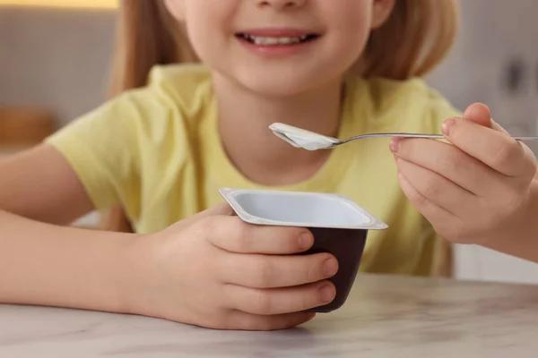 可爱的小女孩 在室内的白色大理石桌子上放着美味的酸奶 — 图库照片