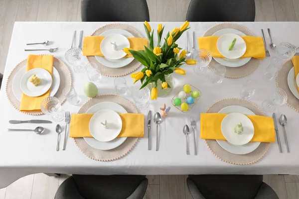 Gözlüklü şenlik masası, boyalı yumurta ve vazo lale, yukarıdan manzara. Paskalya kutlaması