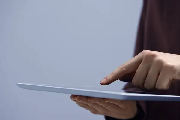 Pandangan Dekat Wanita Menggunakan Tablet Modern Pada Latar Belakang Abu — Stok Foto