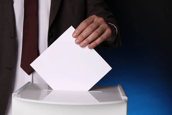 Mann Legt Seine Stimme Die Wahlurne Auf Dunkelblauem Hintergrund Nahaufnahme — Stockfoto