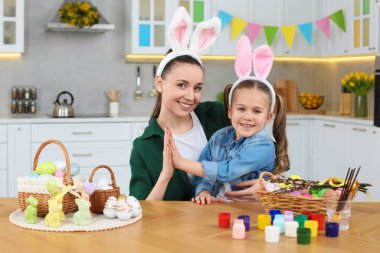 Mutlu anne-kız ve Paskalya yumurtaları mutfakta.