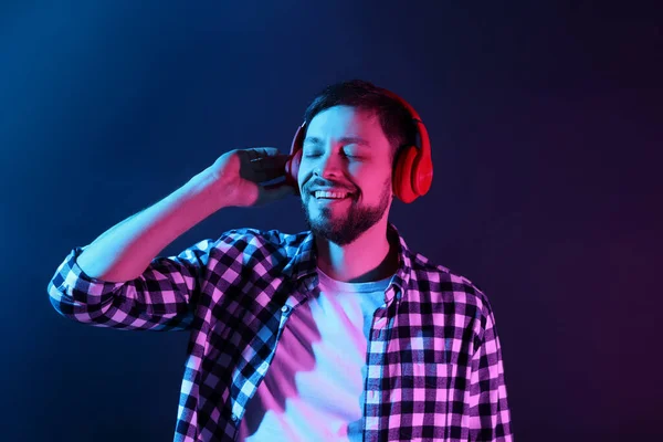 Homem Feliz Fones Ouvido Desfrutando Música Luzes Néon Contra Fundo — Fotografia de Stock