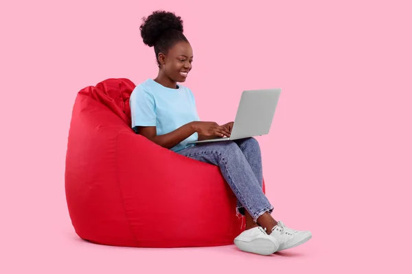 Όμορφη Νεαρή Γυναίκα Φορητό Υπολογιστή Κάθεται Καρέκλα Beanbag Ροζ Φόντο — Φωτογραφία Αρχείου