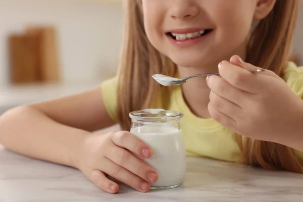 Söt Liten Flicka Med Välsmakande Yoghurt Vid Vitt Marmorbord Inomhus — Stockfoto