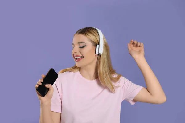Ευτυχισμένη Γυναίκα Στα Ακουστικά Απολαμβάνοντας Μουσική Και Τραγούδι Smartphone Βιολετί — Φωτογραφία Αρχείου