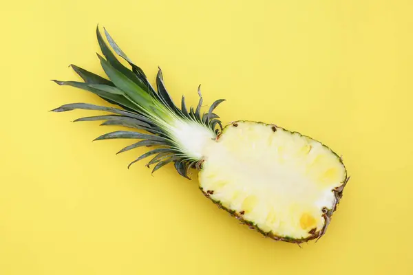 stock image Half of ripe pineapple on yellow background, top view