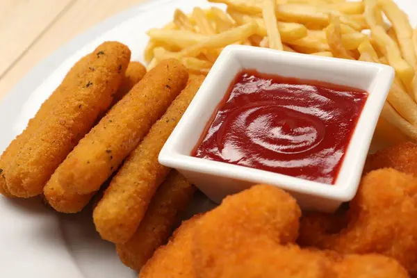 味道鲜美的番茄酱 鸡块和奶酪棒放在盘子里 特写镜头 — 图库照片