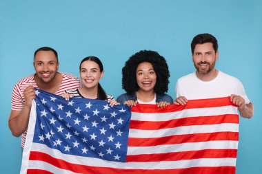 4 Temmuz - ABD 'nin Bağımsızlık Günü. Açık mavi arka planda Amerikan bayrağı taşıyan mutlu arkadaşlar