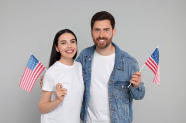 4 Temmuz - ABD 'nin Bağımsızlık Günü. Gri arka planda Amerikan bayrakları olan mutlu çift