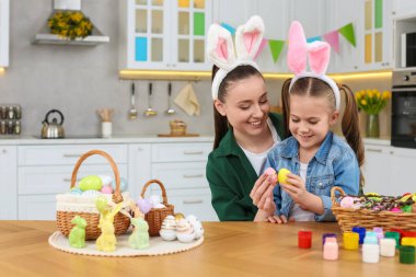 Anne ve kızı mutfakta paskalya yumurtası yiyorlar.