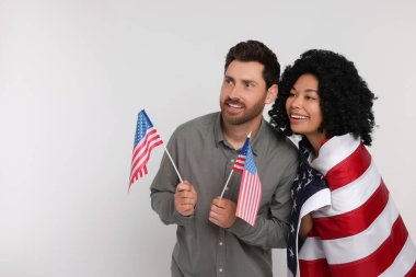 4 Temmuz - ABD 'nin Bağımsızlık Günü. Beyaz arka planda Amerikan bayrakları olan mutlu çift, mesaj için boşluk