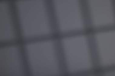 İçerideki koyu gri duvardaki pencerenin gölgesi