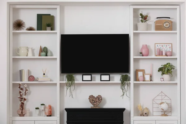 Fernseher Kamin Und Stilvolle Regale Mit Dekorativen Elementen Und Zimmerpflanzen — Stockfoto