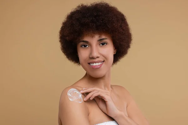 Hermosa Mujer Joven Aplicando Crema Corporal Hombro Sobre Fondo Beige — Foto de Stock