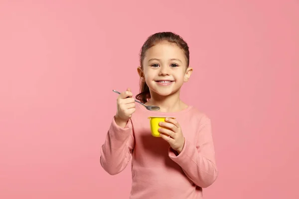 Chica Con Sabroso Yogur Sobre Fondo Rosa — Foto de Stock