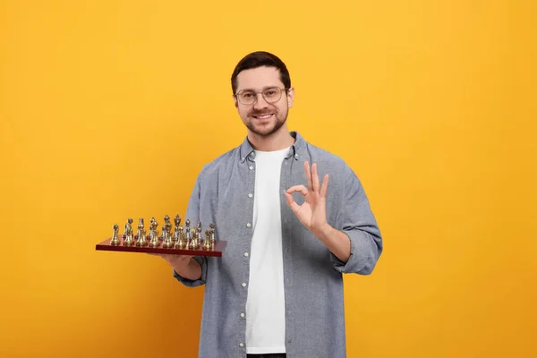 Χαμογελώντας Άνθρωπος Κρατώντας Σκακιέρα Κομμάτια Του Παιχνιδιού Και Δείχνει Χειρονομία — Φωτογραφία Αρχείου