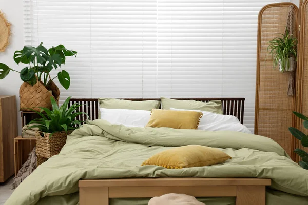 Άνετο Κρεβάτι Και Όμορφα Πράσινα Φυτά Στο Υπνοδωμάτιο — Φωτογραφία Αρχείου