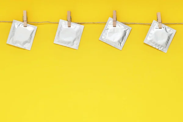 Wäscheleine Mit Verpackten Kondomen Auf Gelbem Hintergrund Platz Für Text — Stockfoto
