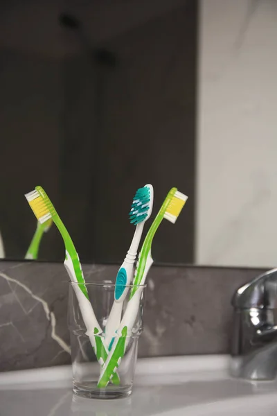 Açık Mavi Yeşil Diş Fırçaları Lavabodaki Cam Tutacağında — Stok fotoğraf