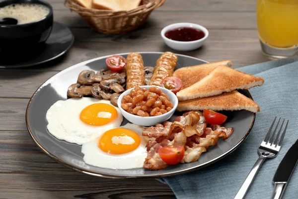 揚げ卵のプレート キノコ トマト ベーコン ソーセージやトーストは 木製のテーブルで提供 クローズアップ 伝統的な英語の朝食 — ストック写真