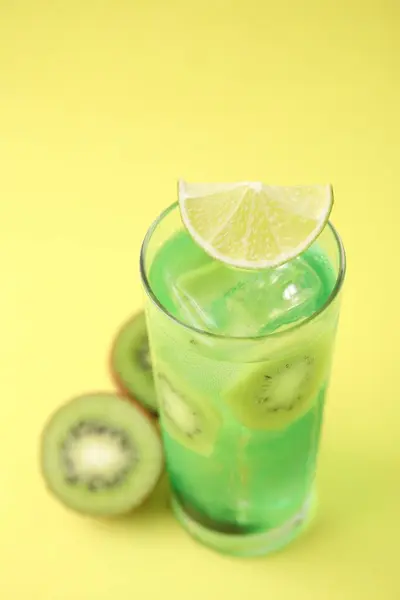 さわやかな飲み物のガラスと黄色の背景にキウイをカット クローズアップ — ストック写真