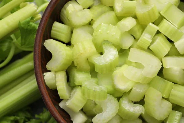 stock image Fresh cut celery stalks in bowl and bunches, top view