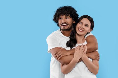 Uluslararası randevu. Açık mavi arka planda kucaklaşan mutlu çift, mesaj için boşluk