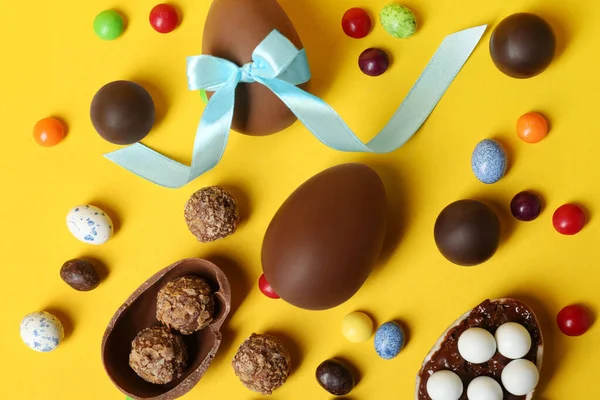 Sabrosos Huevos Chocolate Caramelos Sobre Fondo Amarillo Puesta Plana — Foto de Stock