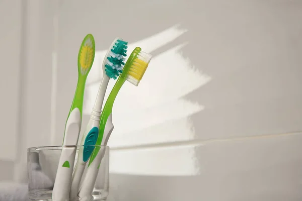 Light Blue Green Toothbrushes White Wall Space Text — Stock Photo, Image
