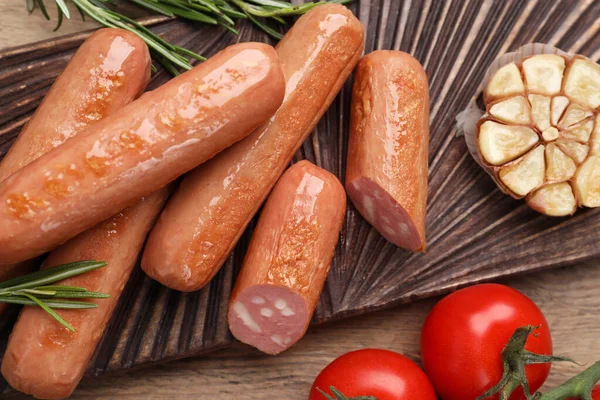 stock image Delicious vegan sausages, garlic and tomatoes on wooden table, flat lay