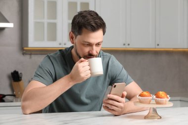 Adam mutfakta kahvaltı ederken akıllı telefon kullanıyormuş. İnternet bağımlılığı