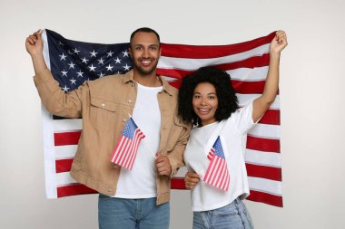 4 Temmuz - ABD 'nin Bağımsızlık Günü. Beyaz arka planda Amerikan bayrakları olan mutlu çift