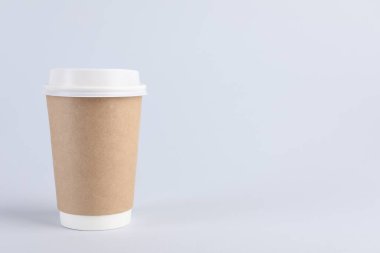 Arka planda plastik kapaklı kağıt bardak, metin için boşluk. Kahve hazır.