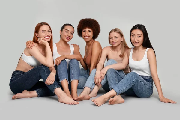Grupo Hermosas Mujeres Jóvenes Sentadas Sobre Fondo Gris Claro —  Fotos de Stock