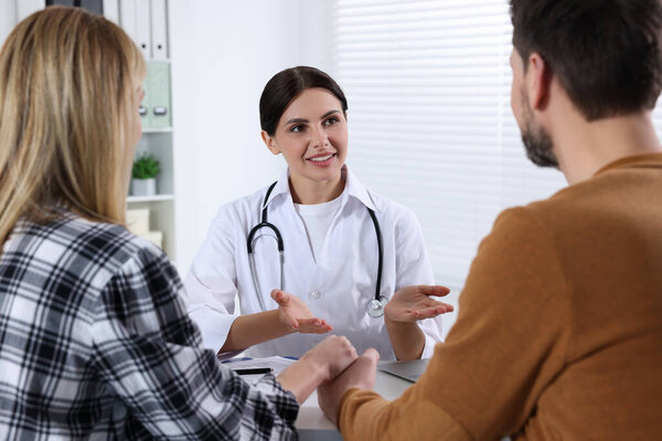 Пара, встречающаяся с врачом по бесплодию в клинике. Консультация пациента