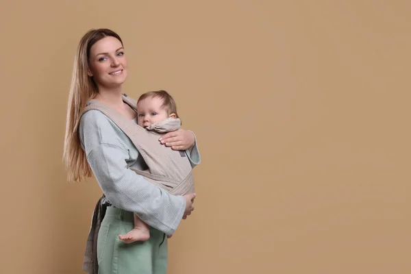 Moeder Houdt Haar Kind Draagdoek Babydrager Lichtbruine Achtergrond Ruimte Voor — Stockfoto