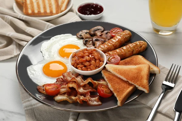 揚げ卵のプレート キノコ トマト ベーコン ソーセージとトースト白い大理石のテーブルの上で提供 クローズアップ 伝統的な英語の朝食 — ストック写真