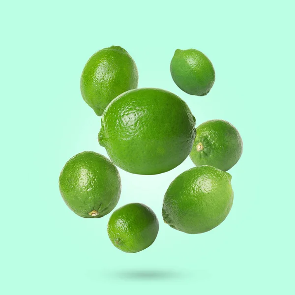 Fresh Lime Fruits Falling Aquamarine Background — Stock Photo, Image