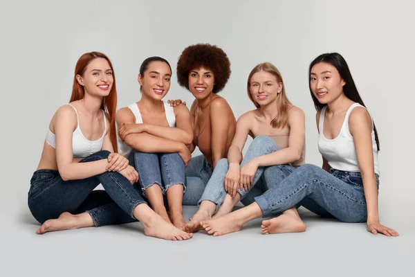 Група Красивих Молодих Жінок Сидять Світло Сірому Фоні — стокове фото