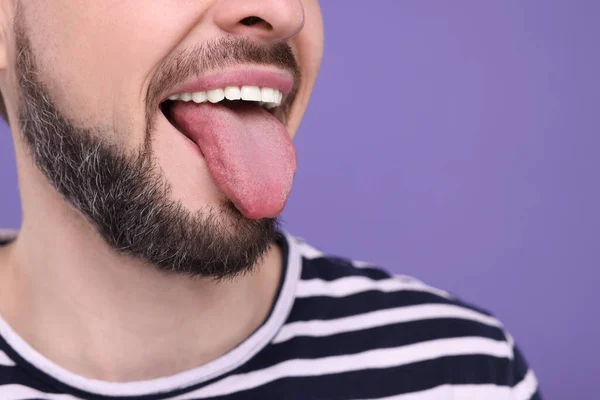 紫色の背景に彼の舌を示す幸せな男 クローズアップ テキストのスペース — ストック写真