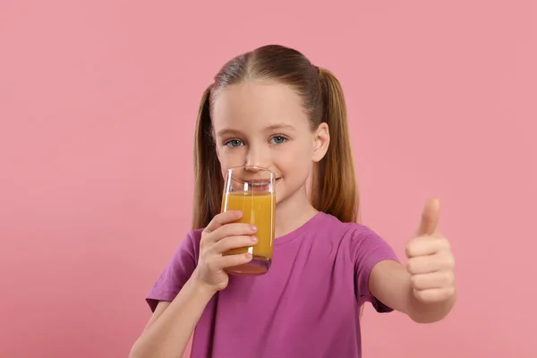 Симпатична Маленька Дівчинка Склянкою Свіжого Соку Показує Великі Пальці Рожевому — стокове фото