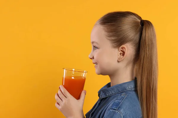Χαριτωμένο Κοριτσάκι Ένα Ποτήρι Φρέσκο Χυμό Πορτοκαλί Φόντο Χώρος Για — Φωτογραφία Αρχείου
